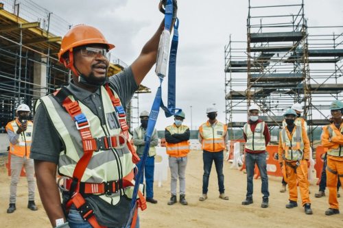 Site safety professionals in New York at a construction site, one pointing upwards towards the structure.