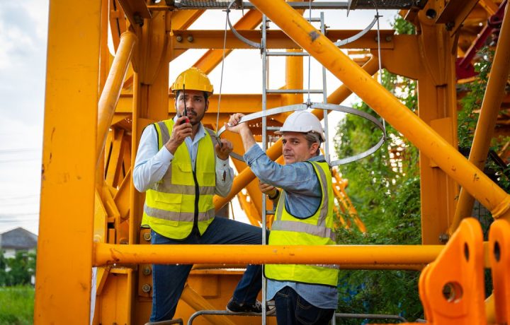 two-men-in-yellow-vests-are-working-on-a-construct-2024-07-23-19-28-53-utc